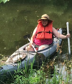 Conservation Specialist, Betty McCracken, in a kayak, is holding a pole to assess the slope and depth of the pond for the fuure water intake.  Picture taken at Clover Forest Farm by Sebastian Volcker