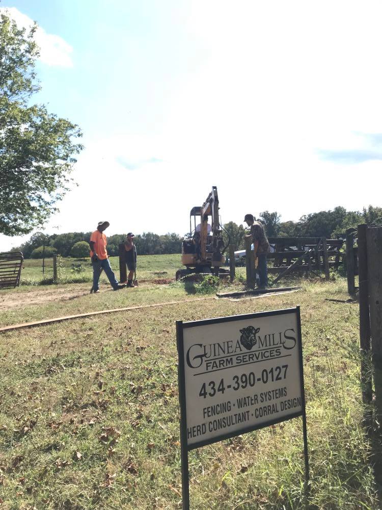 Background: Tony, Manuel, Charles and Jessy setting a gate post.
Foreground: Guinea Mills' yard sign.